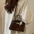 Premium suede mini crossbody bag with adjustable leather strap from Plush Fashion Hub, shown with sleek design and compact size.