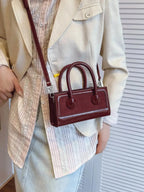 Plush Fashion Hub premium leather top-handle crossbody bag with structured design and versatile style, shown in black.