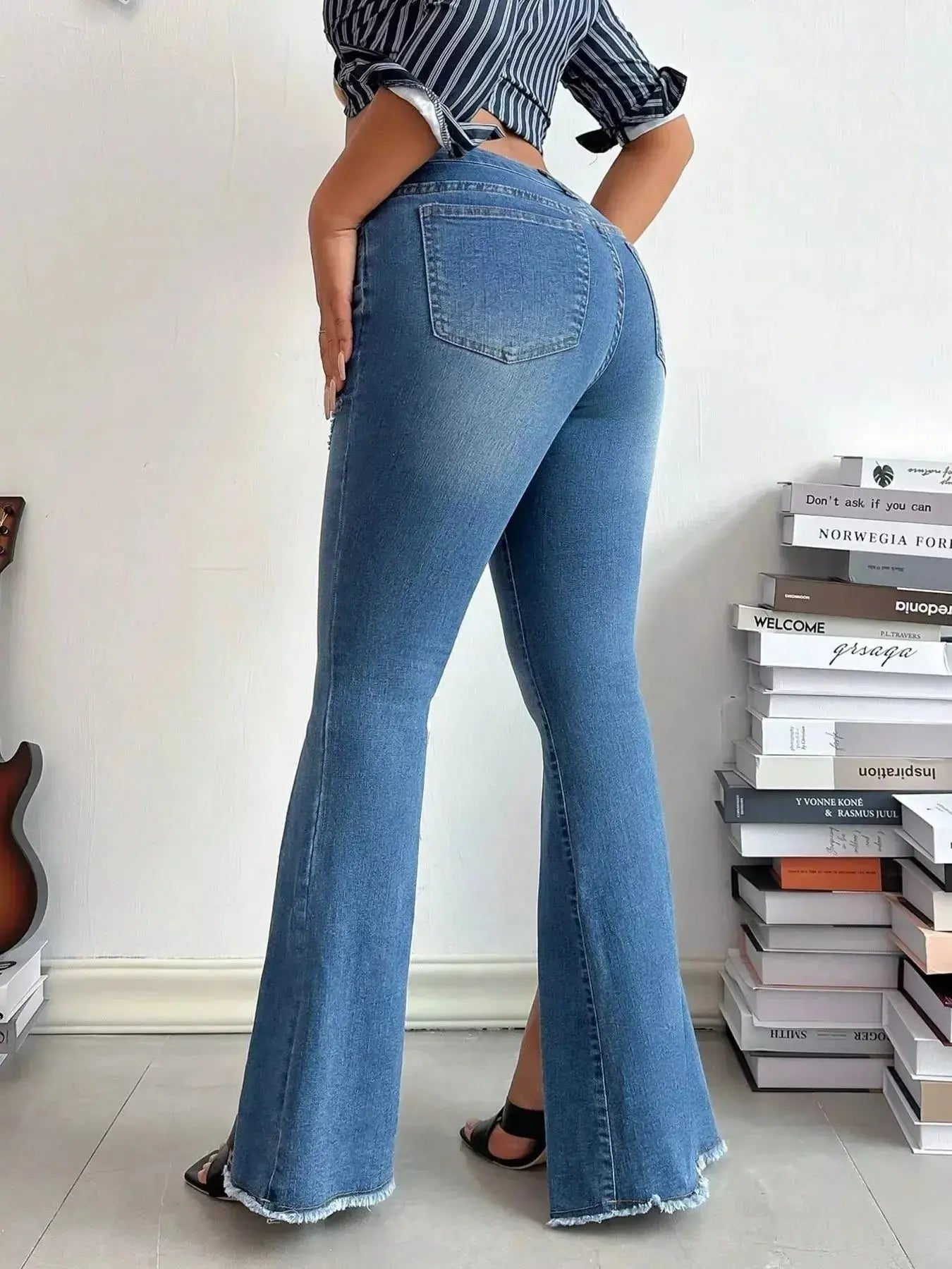 Women's high-rise distressed slit flare jeans with vintage-inspired denim style, featuring a fitted waist and flared leg.