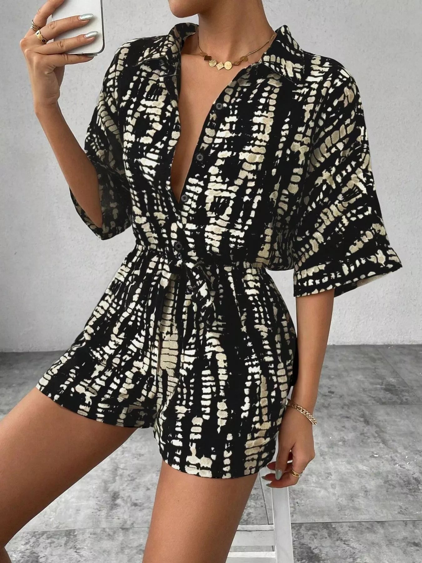 Striped button-up belted romper by Trendsi featuring a stylish design, collar, and waist tie for a casual, trendy look.