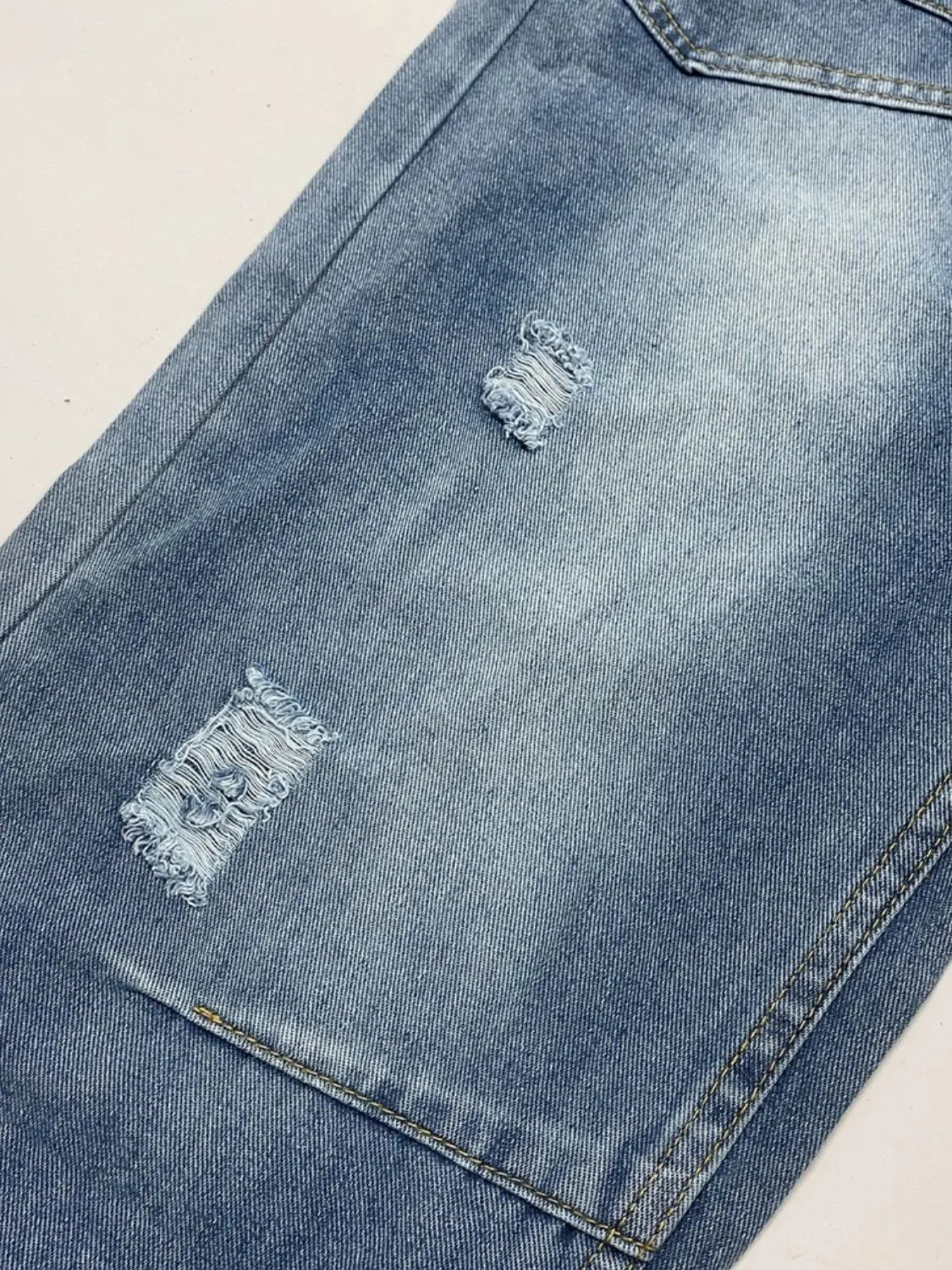 Distressed denim jeans from Plush Fashion Shop featuring front and back pockets, with a casual, worn-in style.