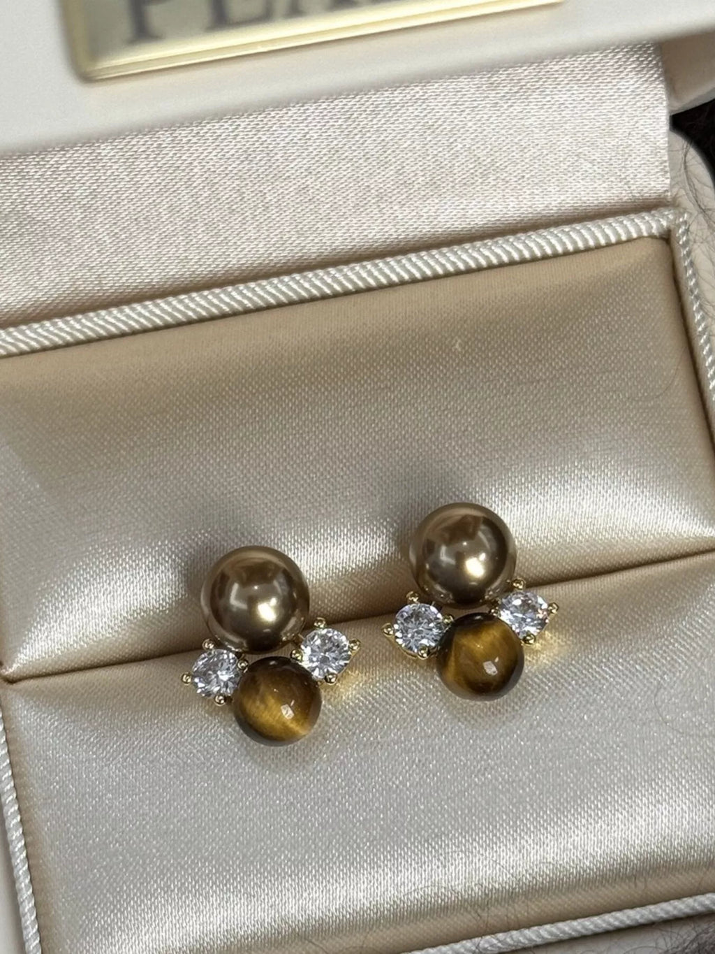 Tiger Eye stud earrings by Trendsi featuring polished, round gemstone studs with gold-tone settings.