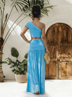 Trendsi one-shoulder top and ruched maxi skirt set displayed on a model, showcasing stylish, coordinated fashion ensemble.