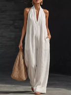 Black halter neck wide-leg jumpsuit from Trendsi, featuring a fitted bodice and flowing pant legs, displayed on a model.