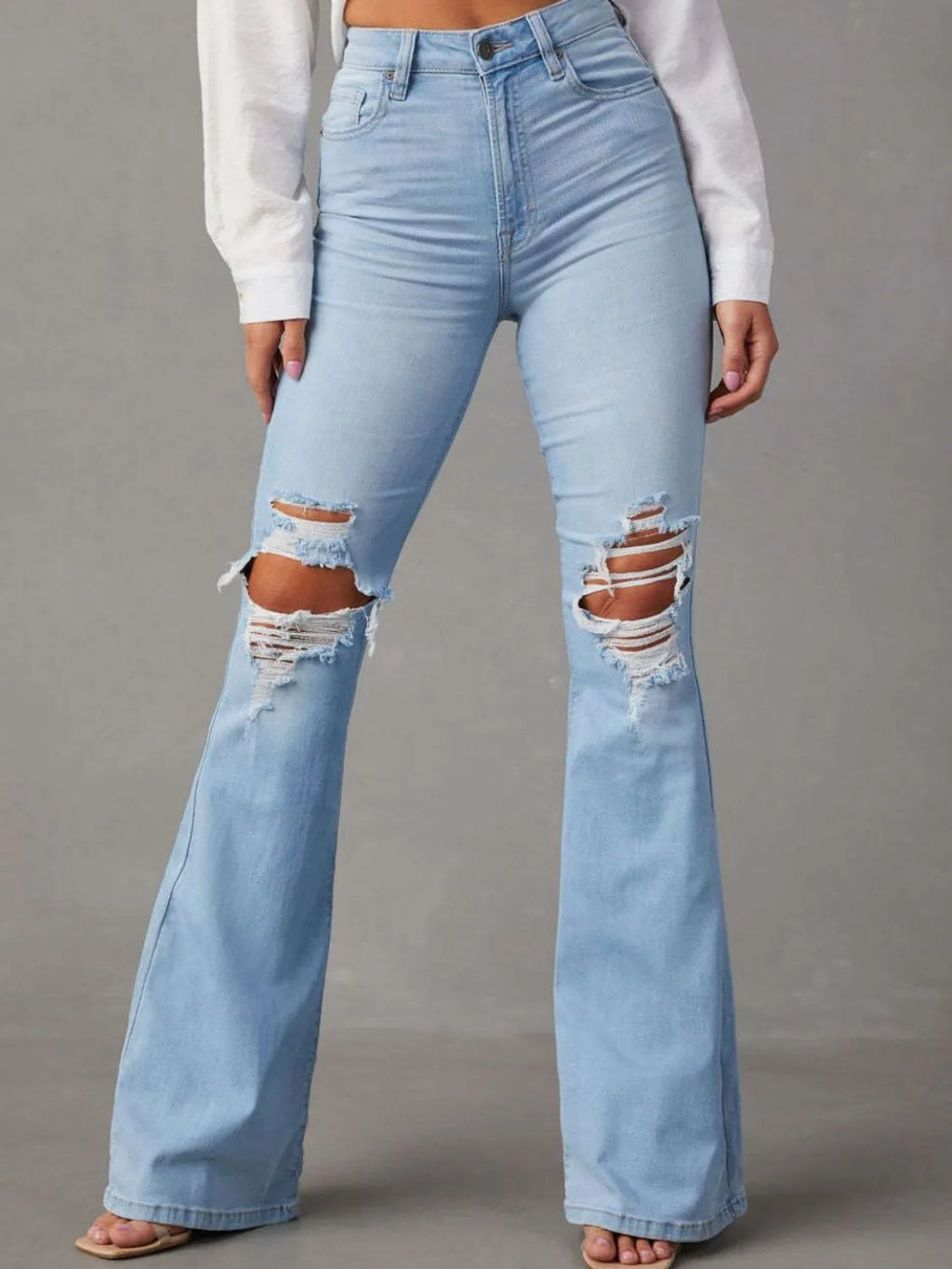 Distressed blue jeans with multiple pockets, featuring a trendy worn-in look, by Trendsi.