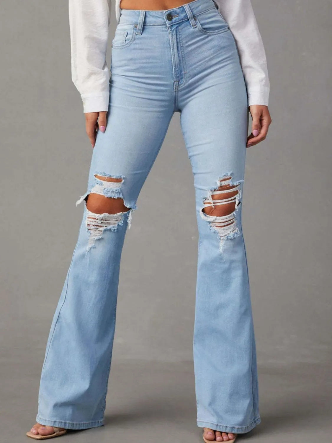 Distressed blue jeans with multiple pockets, featuring a trendy worn-in look, by Trendsi.