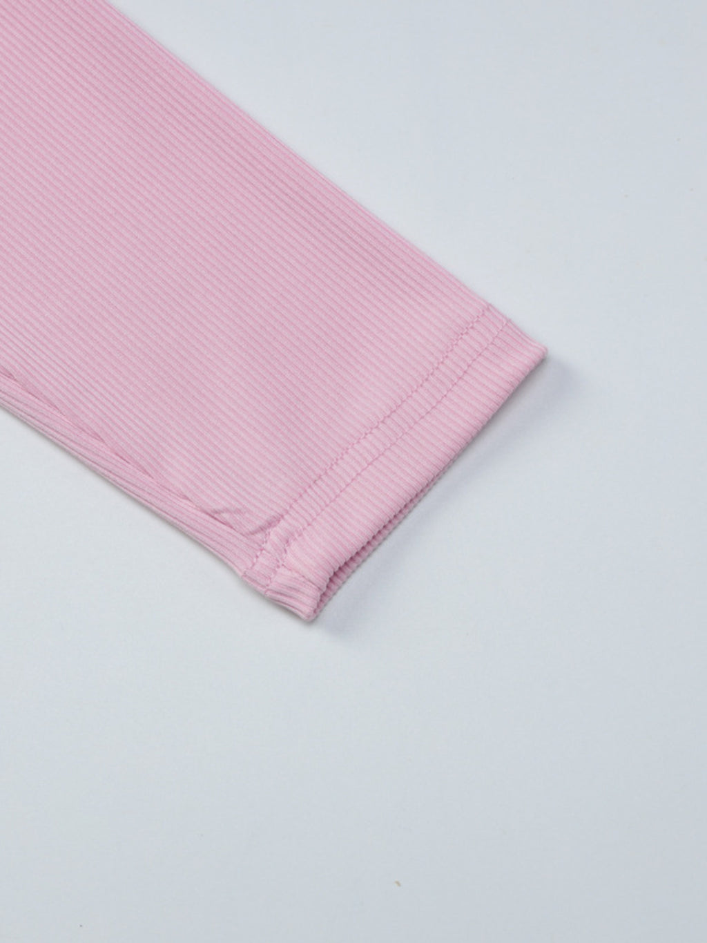Women's ribbed knit button-front long sleeve T-shirt by Trendsi, showing a fitted, ribbed texture with a row of buttons down the front.