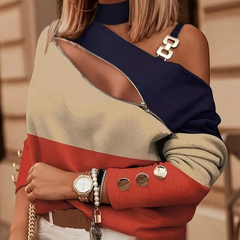Color-blocked top in navy, beige, and red with a diagonal zip detail, metal strap hardware, and gold-tone buttons.