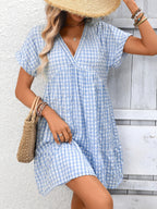 Lightweight plaid V-neck mini dress with ruffle hem from Trendsi, perfect for seasonal fashion and casual outings.