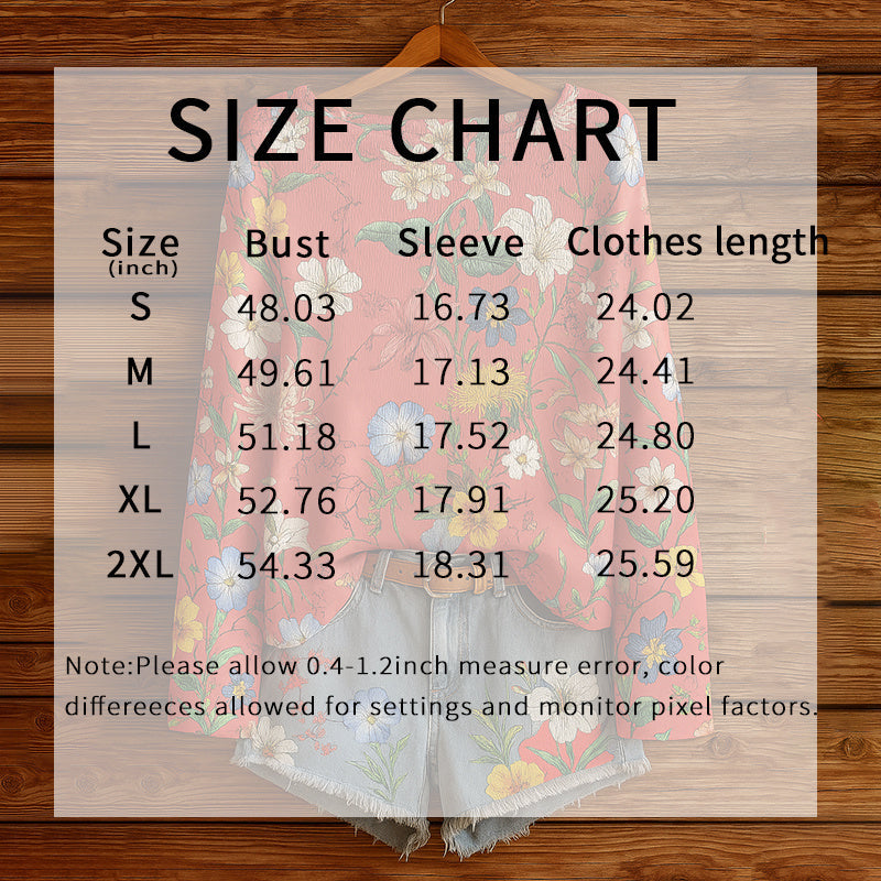A floral long-sleeved top in soft pink with multicolor wildflower print, overlaid with a garment size chart.