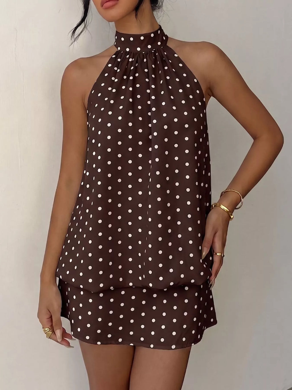 Polka dot halter neck mini dress by Trendsi, featuring a stylish design with a fitted bodice and playful pattern.