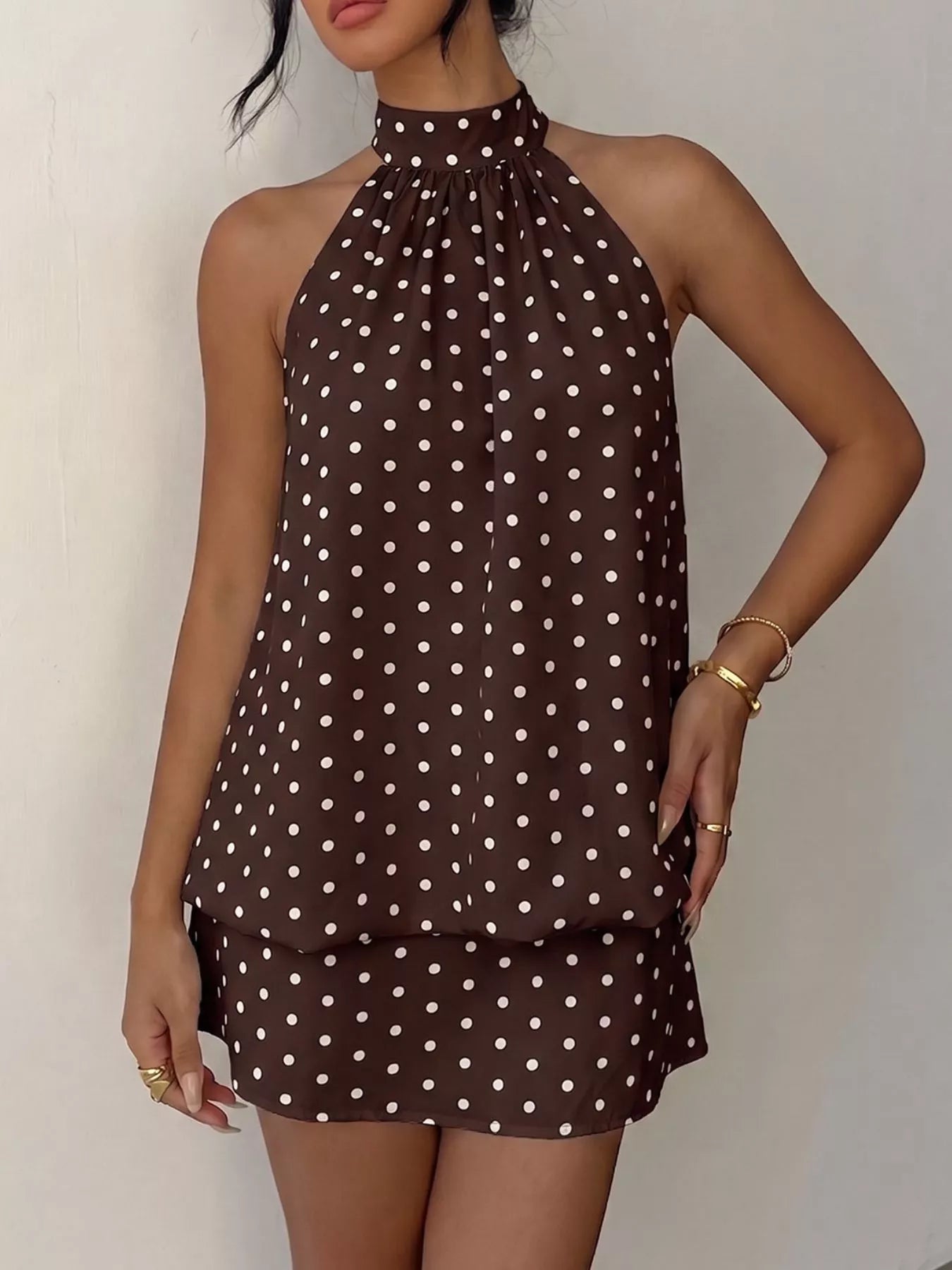 Polka dot halter neck mini dress by Trendsi, featuring a stylish design with a fitted bodice and playful pattern.