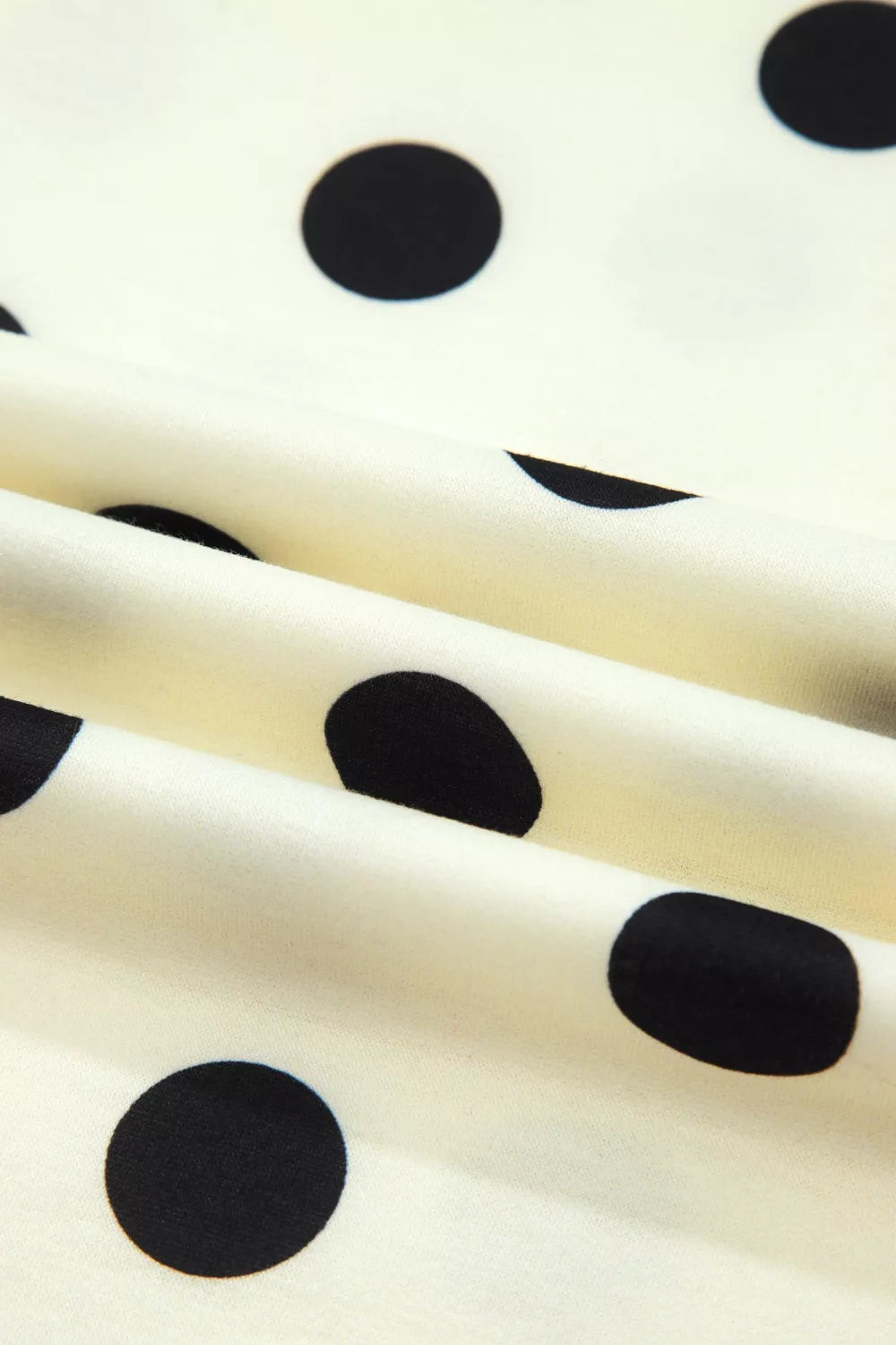 Polka dot print high neck dolman top by Trendsi, featuring a relaxed fit and long sleeves, displayed on a hanger against a plain background.