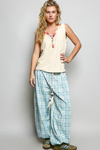 Ribbed V-neck tank top with contrast floral neckband, stylish sleeveless top from Trendsi, shown in a close-up view.