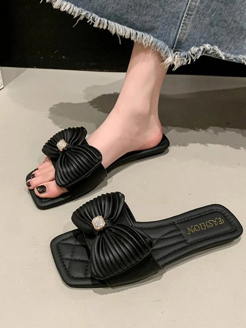Women's beige faux leather flat sandals with a decorative bow-knot detail, stylish and comfortable for casual wear.