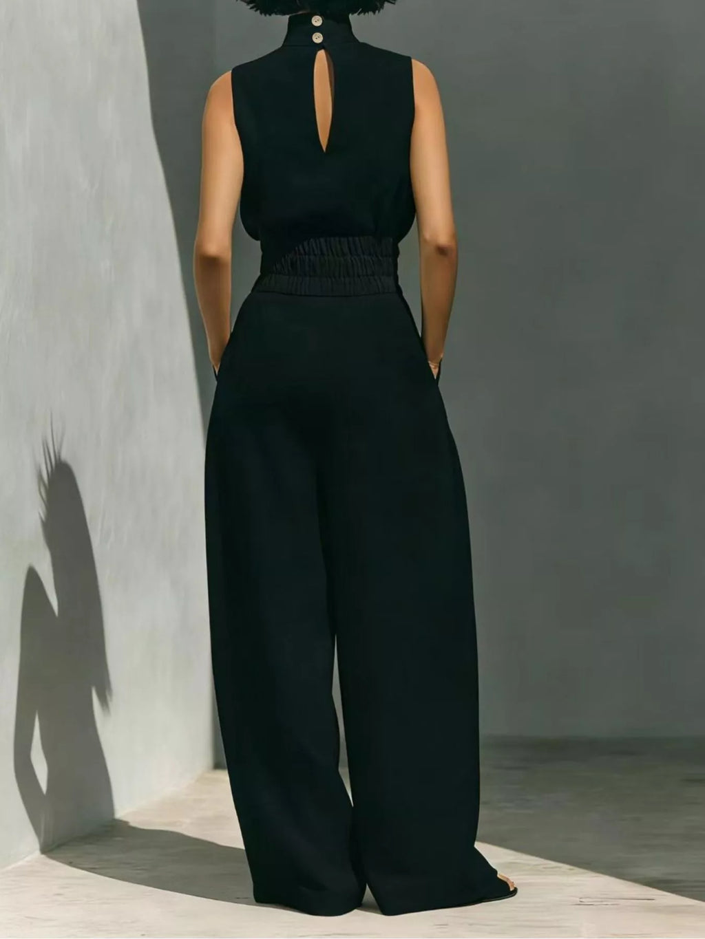 Sleeveless turtleneck top and wide-leg pants set by Trendsi, featuring a sleek, stylish look with neutral tones and comfortable fit.