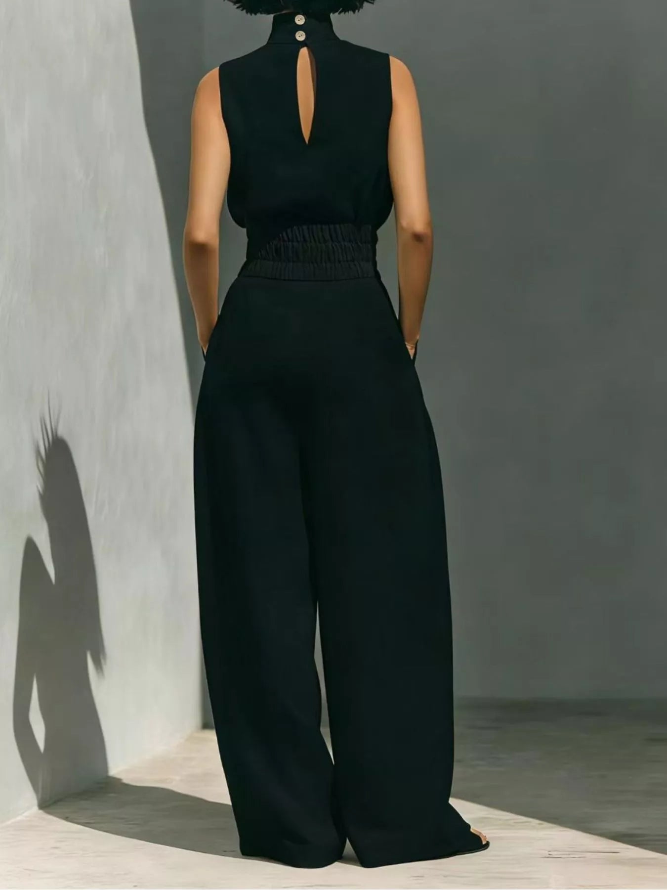 Sleeveless turtleneck top and wide-leg pants set by Trendsi, featuring a sleek, stylish look with neutral tones and comfortable fit.