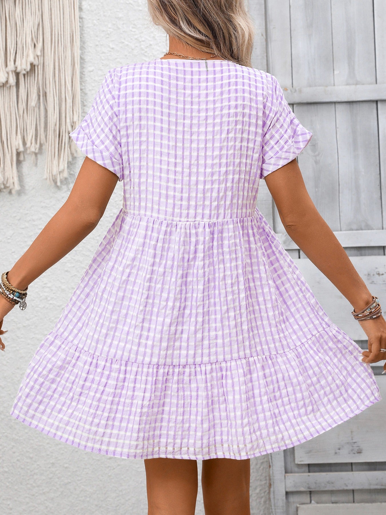 Lightweight plaid V-neck mini dress with ruffle hem from Trendsi, perfect for seasonal fashion.