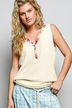 Ribbed V-neck tank top from Trendsi featuring a contrast floral neckband, sleeveless design, and fitted ribbed fabric.