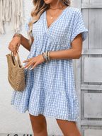 Lightweight plaid V-neck mini dress with ruffle hem from Trendsi, perfect for seasonal fashion and casual outings.