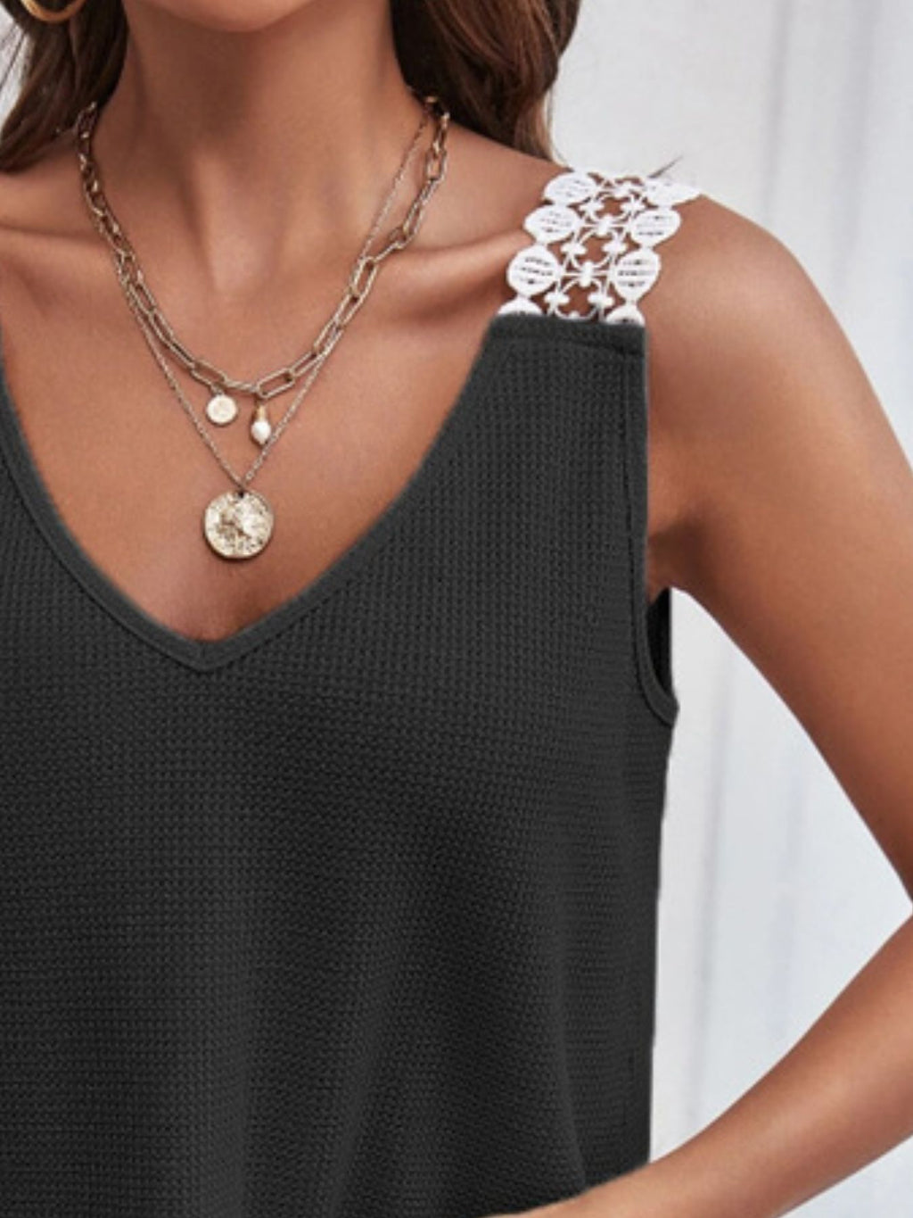 Women's waffle knit tank top with V-neck and lace trim, trendy sleeveless top from Trendsi featuring textured fabric and delicate detailing.