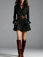 A woman in a dark green plaid shirt dress with a wide brown belt and matching knee-high leather boots.