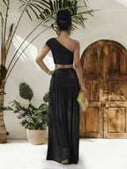 Trendsi one-shoulder top and ruched maxi skirt set displayed on a mannequin, featuring stylish beige fabric with draped details.