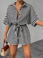 Striped button-up belted romper from Trendsi with a collar, long sleeves, and a waist tie, styled for casual or semi-formal wear.