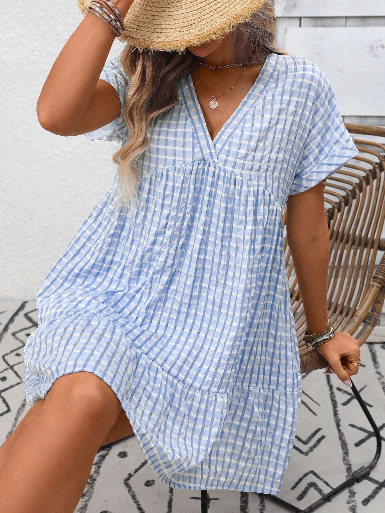 Lightweight plaid V-neck mini dress with ruffle hem by Trendsi, perfect for seasonal fashion and casual outings.