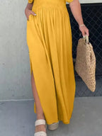 Full size slit V-neck smocked waist maxi dress by Trendsi, plus size, shown with flowing fabric and elegant design.