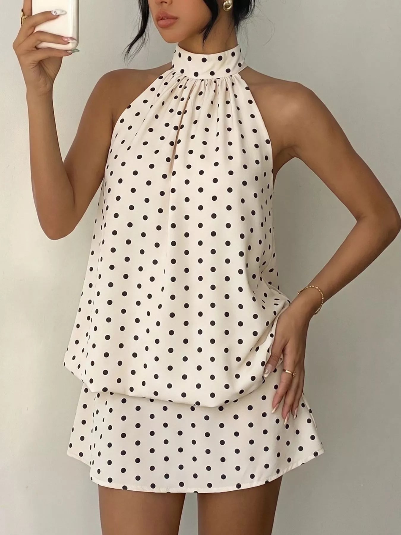 Polka dot halter neck mini dress by Trendsi featuring a fitted silhouette and stylish halter straps.