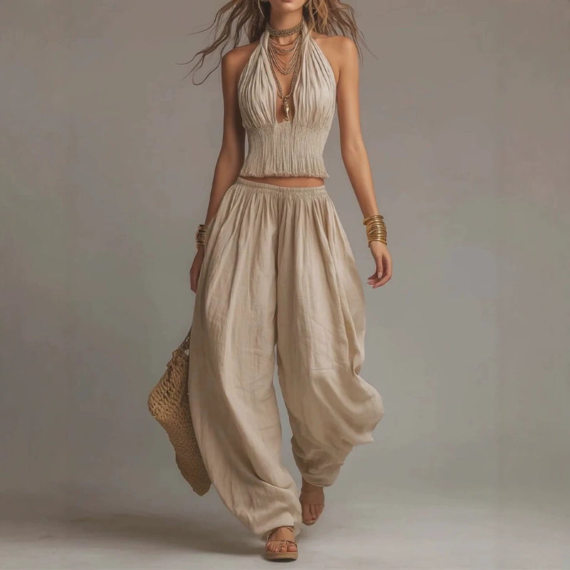 Beige two-piece set featuring a pleated halter top and high-waisted, flowy harem-style pants.