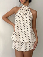 Polka dot halter neck mini dress by Trendsi featuring a fitted silhouette and stylish design, perfect for casual or semi-formal occasions.