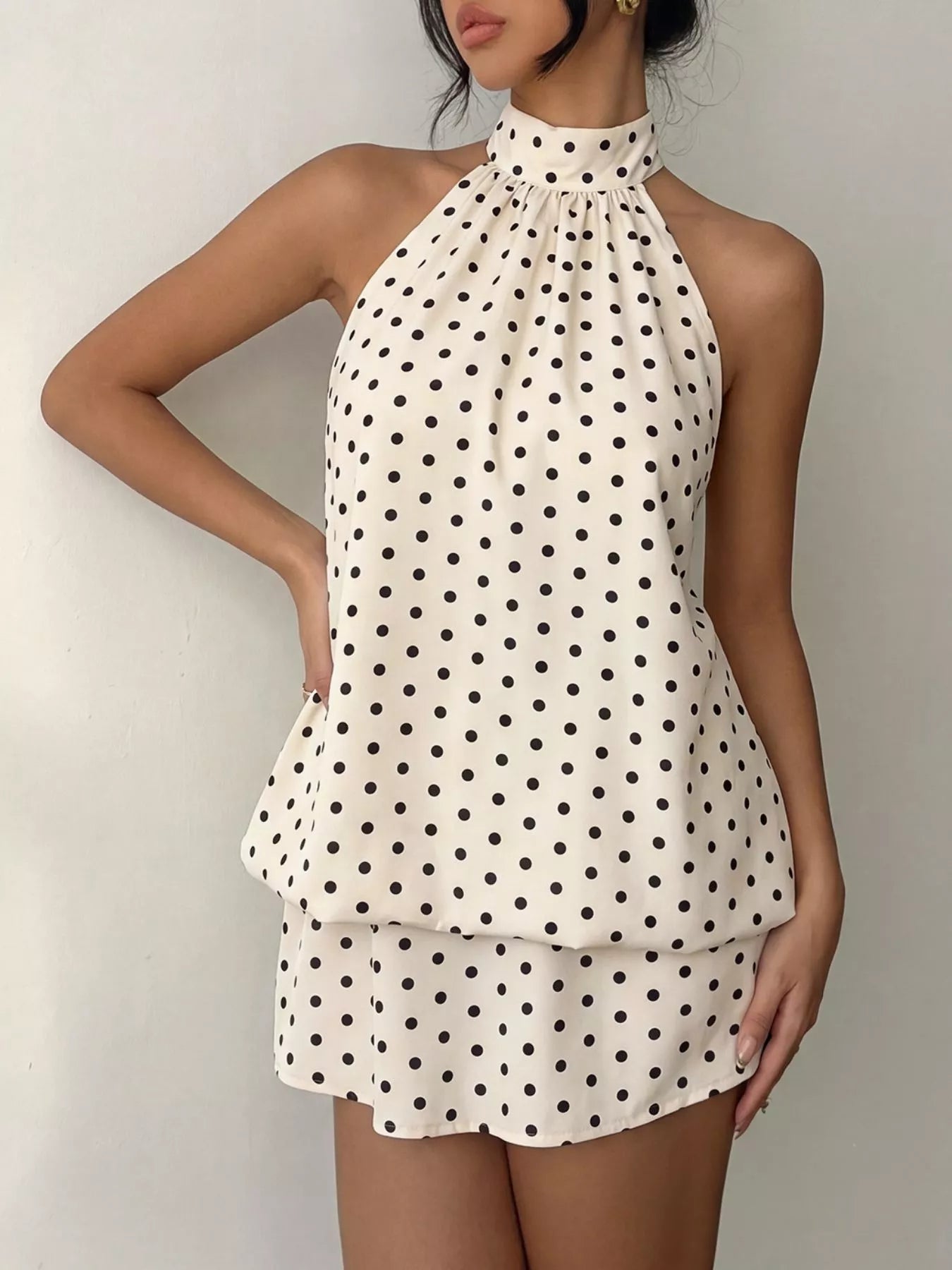 Polka dot halter neck mini dress by Trendsi featuring a fitted silhouette and stylish design, perfect for casual or semi-formal occasions.
