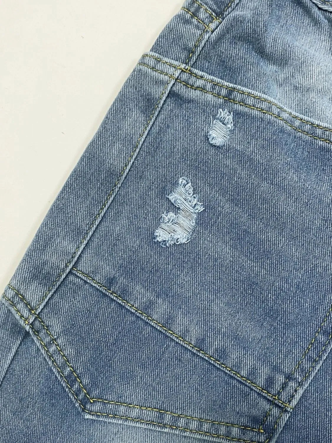 Distressed Plush Fashion Shop denim jeans with pockets, featuring a casual, ripped design and classic five-pocket style.