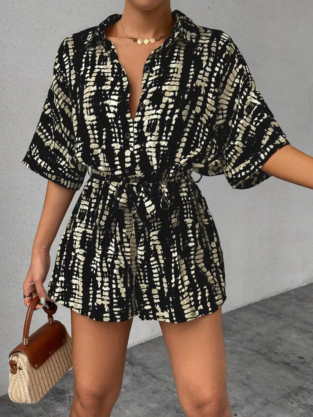 Striped button-up belted romper by Trendsi featuring a fitted waist and short sleeves, styled with vertical stripes and a collar.