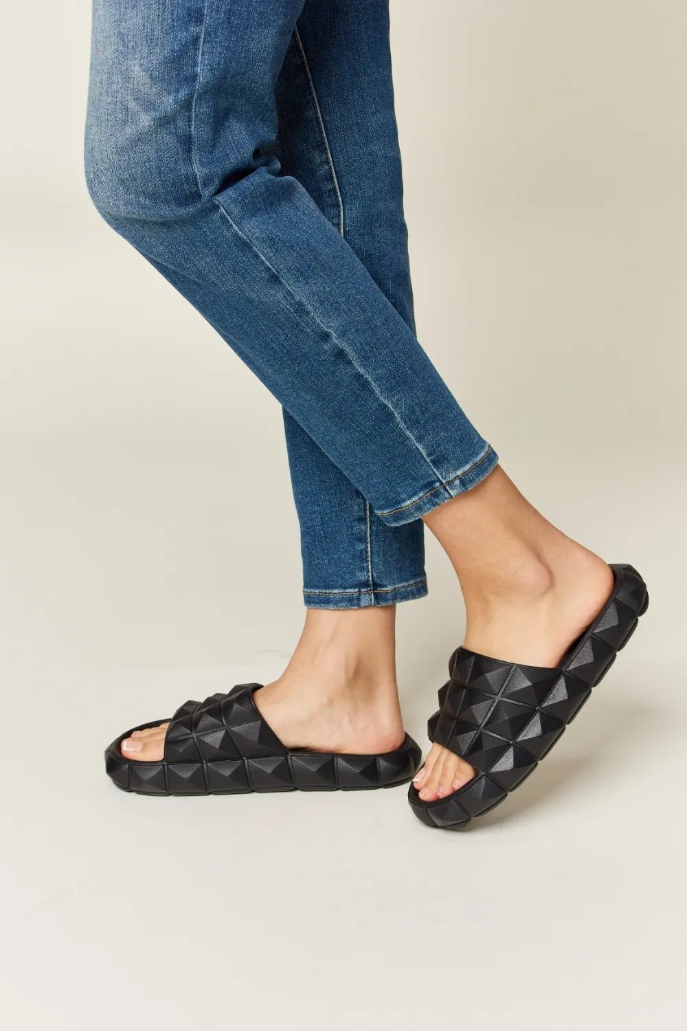 Women's studded toe band footbed sandals by Trendsi featuring edgy pyramid studs and comfortable slide design.
