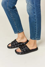 Women's studded toe band footbed sandals with pyramid studs, edgy comfort slides by Trendsi, featuring a casual open-toe design.